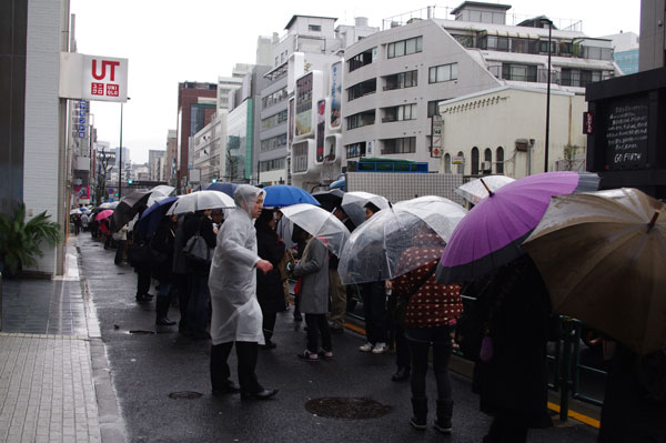 （写真2）雨が降る中、割引クーポンを求めて行列をなす人々。image by JINS