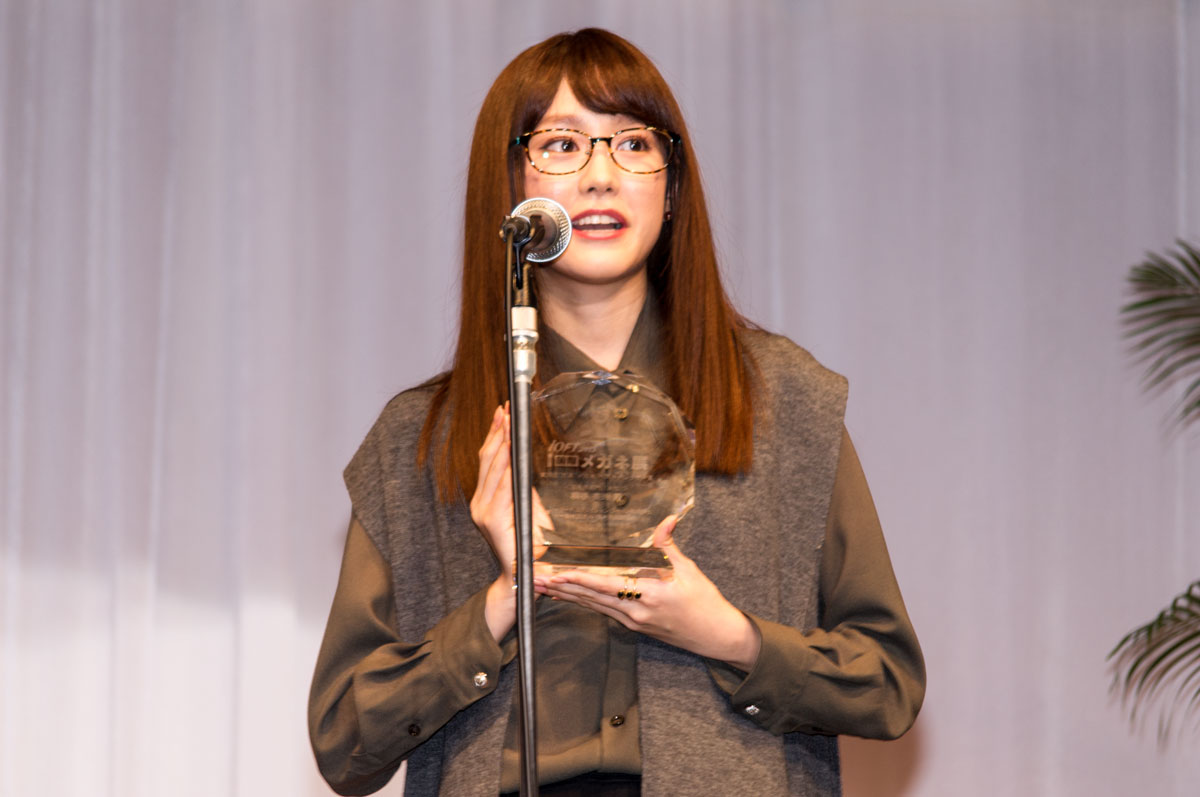 トロフィーを手に受賞のよろこびを語る桐谷美玲。掛けているメガネは、Hug Ozawa（ハグ・オザワ）EYEs CLOUD（アイクラウド）。