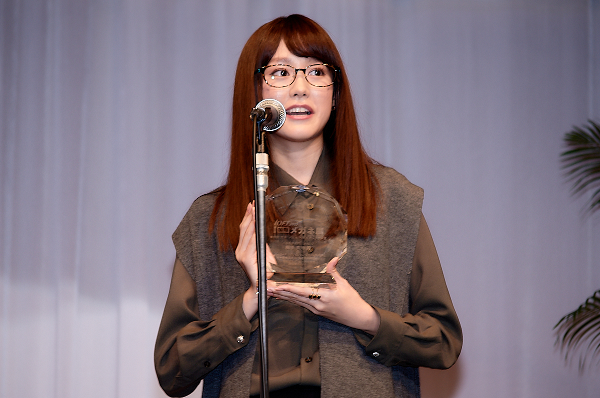 トロフィーを手に受賞のよろこびを語る桐谷美玲。掛けているメガネは、Hug Ozawa（ハグ・オザワ）EYEs CLOUD（アイクラウド）。
