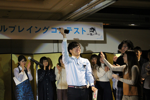 表彰式でトロフィーを掲げる小川真弘さん。